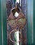 Old rusty metal padlock with key on green metal gates closeup