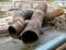 Old rusty metal pipes. Construction work to replace heating pipes. Replacing old pipes with new ones. Reconstruction of the cold