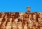 Old rusty metal roof with brick chimney against blue sky