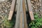 Old rusty railway lines with grey stone chippings lying on the ground outdoors. Natural industrial background texture