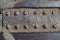 Old rusty rectangular plate with rivets on a metal surface