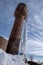 Old rusty rickety water tower and a huge icicle on it