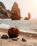 Old rusty round floating marine mines on the beach with rocky shore and sea background.