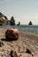 Old rusty round floating marine mines on the beach with rocky shore and sea background. Pollution, nature protection