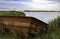 Old Rusty Rowboat Sits On The Bank of A Lake