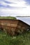Old Rusty Rowboat Sits On Side Of Riverbank