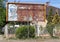 Old rusty ruined billboard next to a house