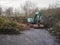 Old rusty and scratched excavator on a site in a forest or park. Heavy industry equipment with long usage life