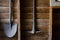 Old rusty Shovel hanging on the wooden wall in a barn, the image in dark tone with shadow.