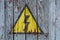 Old rusty sign danger high voltage on a wooden wall /