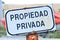 Old rusty sign in Spanish that translates Private Property