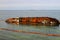 An old rusty tanker flooded and lies in Odessa, Ukraine. Oil spills from the ship and pollutes the sea water