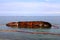 An old rusty tanker flooded and lies in Odessa, Ukraine. Oil spills from the ship and pollutes the sea water