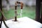 Old rusty tap on a sink with flowing water in a rural yard
