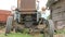 An old rusty tractor stands near the field. The machine for agriculture is waiting for the processing of the field