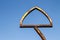 Old rusty triangle-shaped metal frame against blue sky