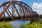 Old rusty truss railroad bridge over the Red River on the border