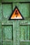 Old rusty warning high voltage sign on cracked wooden surface