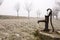 Old rusty water pump on the countryside in winter