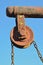 Old rusty well pulley and chain, blue sky as background