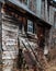 Old rusty Wheelbarrow leans against decrepit barn