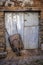 Old rusty wheelbarrow supported by a metal door, rural scene