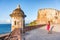 Old San Juan city tourist taking photo in Puerto Rico. Woman using phone taking pictures of ruins of watch tower of San Cristobal