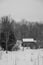 Old sawn log cabin in the snow in winter landscape bw