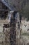 Old scary abandoned fence near a ruined house  burnt tree and wire