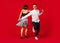 Old-school fashioned young couple dancing isolated on red background