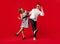 Old-school fashioned young couple dancing  on red background