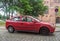 Old scrap car red Opel Astra hatchback parked