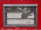 Old scruffy caravan window with steel frame and slatted windows with cracked old white paint with a red surround with rivets