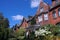 Old semi-detached houses with gables and summer flowers in lush gardens