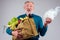 Old senior grandfather choosing between polyethylene disposable package vs cotton reusable shopper bag full of natural