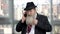 Old senior long-bearded businessman talking on phone.