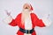 Old senior man with grey hair and long beard wearing santa claus costume crazy and mad shouting and yelling with aggressive