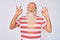 Old senior man with grey hair and long beard wearing striped tshirt relax and smiling with eyes closed doing meditation gesture