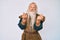 Old senior man with grey hair and long beard wearing viking traditional costume doing money gesture with hands, asking for salary