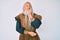 Old senior man with grey hair and long beard wearing viking traditional costume with hand on chin thinking about question, pensive