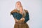 Old senior man with grey hair and long beard wearing viking traditional costume with hand on chin thinking about question, pensive