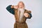 Old senior man with grey hair and long beard wearing viking traditional costume smiling doing talking on the telephone gesture and