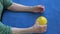 Old senior woman hands doing rehabilitation exercises after stroke with yellow  ball