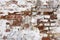 Old shabby damaged plaster on the brick walls of houses close-up