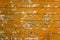 Old shabby orange metal wall with colored scraps of paper ads of different shapes and sizes. horizontal lines. rough surface