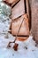 Old shed on snow covered hill with rusty shovel against battered wooden wall