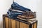 Old shoes and  stack of blue jeans  lie on a vintage suitcase. The concept of travel and comfortable equipment