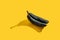 Old shriveled blackened bananas on yellow background