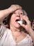 Old sick woman with asthma inhaler