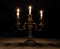Old silver chandelier with three lit candles